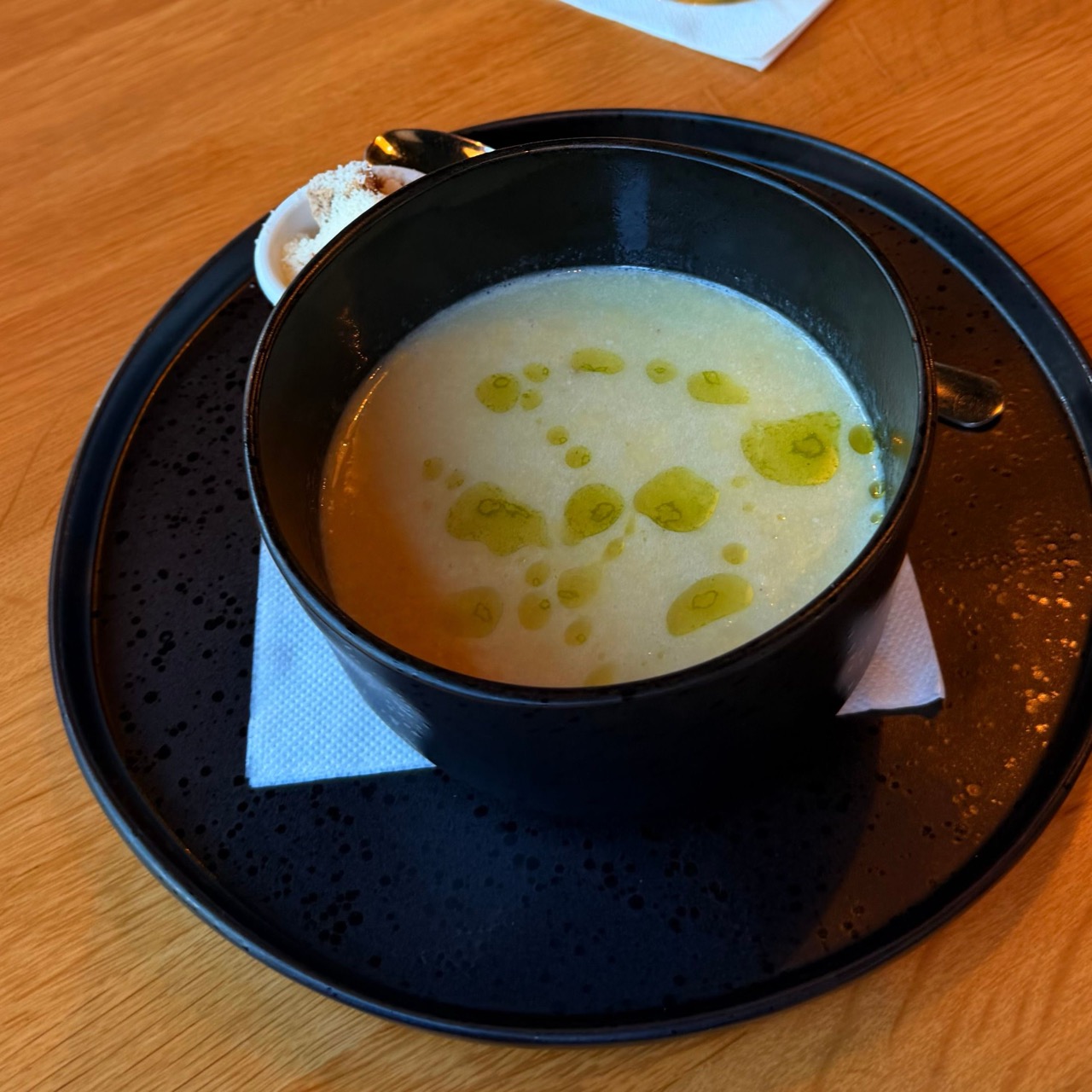 Bowl of soup served on a plate with utensils at Brejk Bistro Prešov