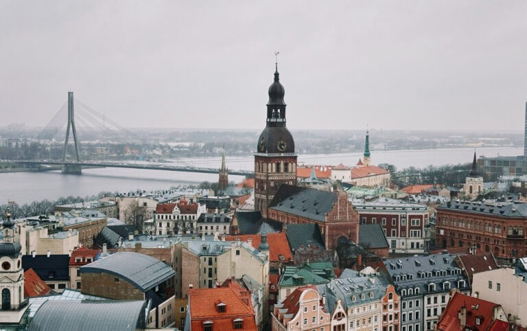 St. Peter’s Church tower in Riga, its steep spire and roof seen from the climb, with a sign on the side