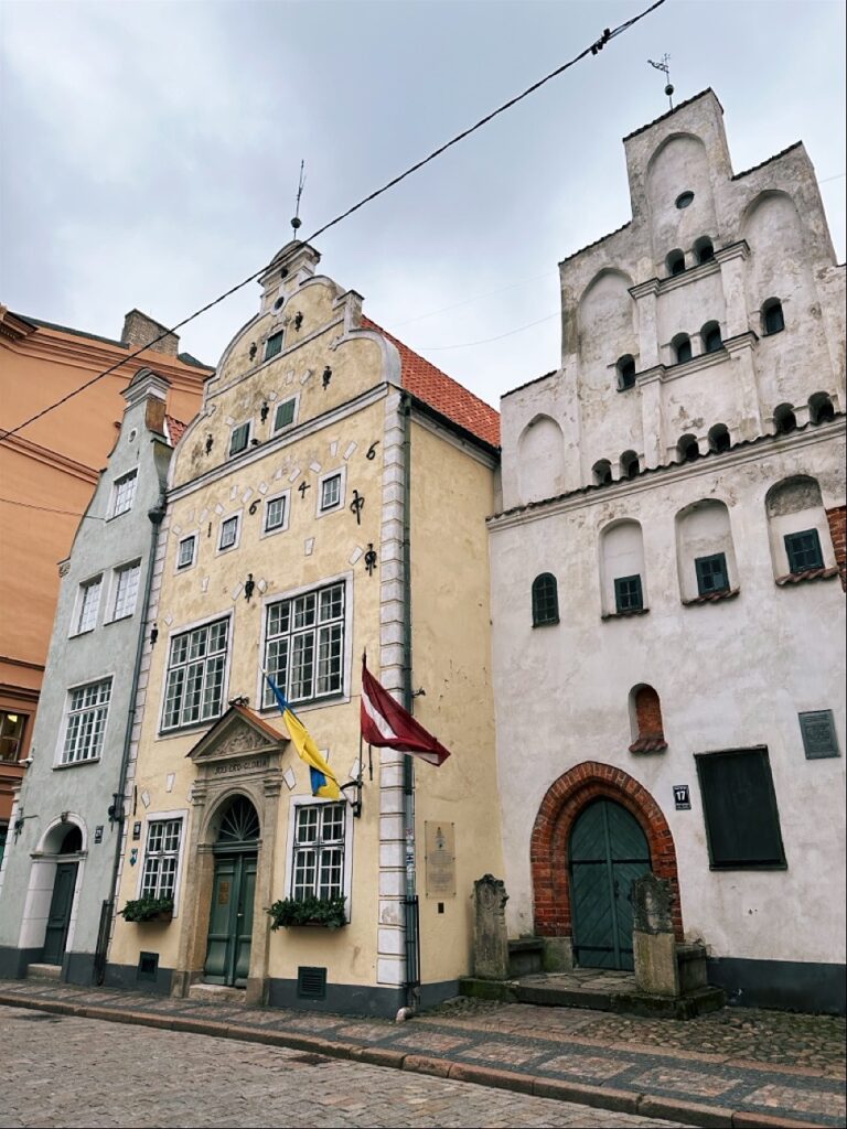 Historic building facade with arched doorway, windows and street view in Riga