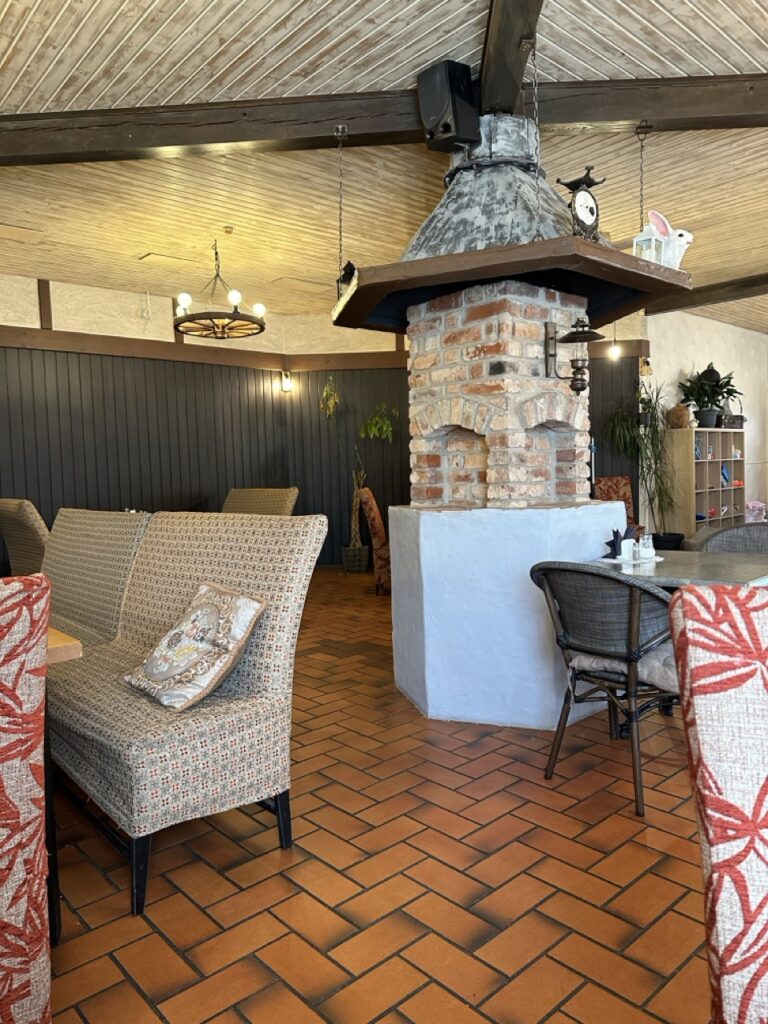 Cozy wooden restaurant interior with chairs around a table, warm lighting and polished floor