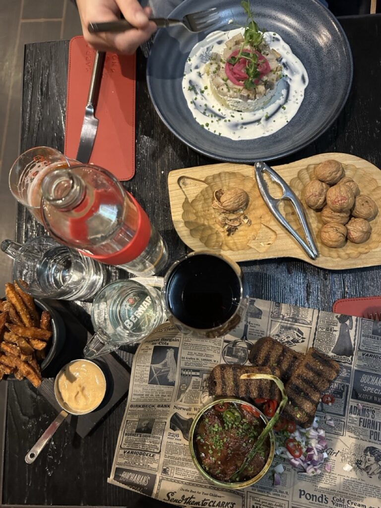 A plate of assorted vegetables and other dishes on a table beside a sign