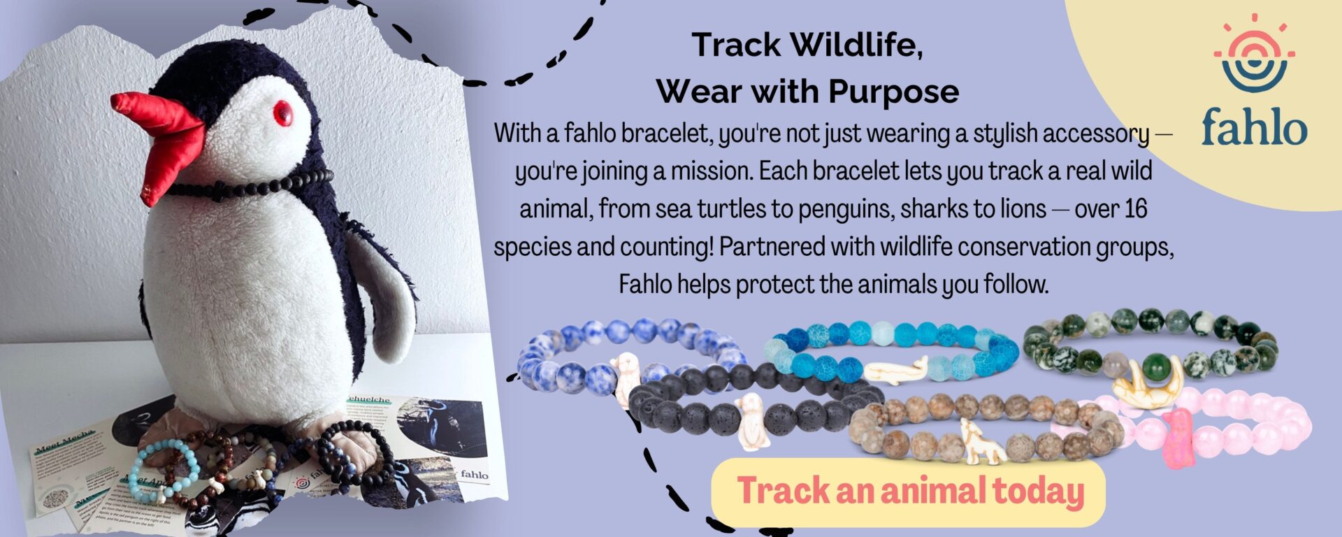 A plush penguin sits next to several beaded wildlife tracking bracelets on a table