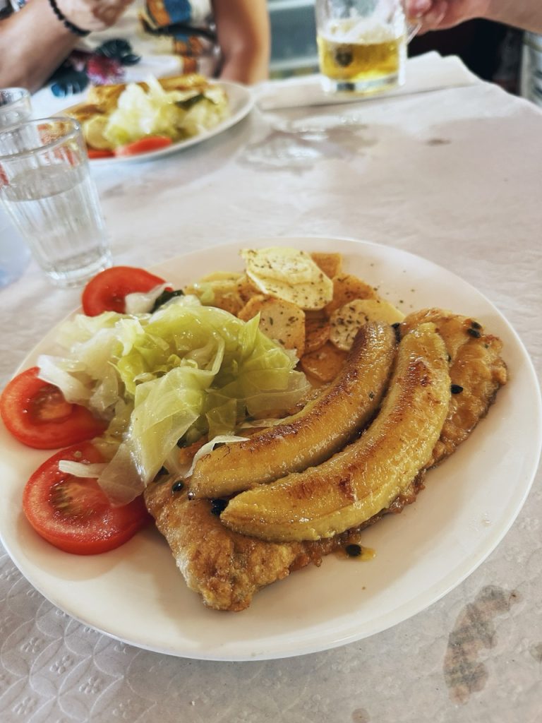 Fried fish topped with bananas served with salad and potatoes in Madeira