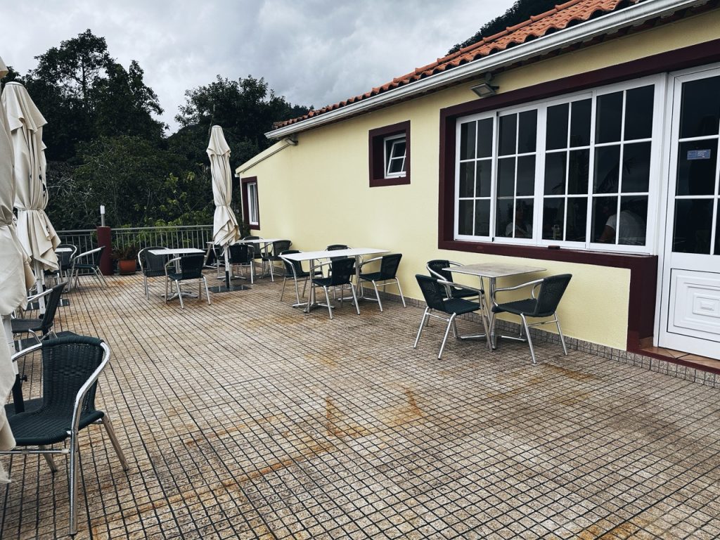 Outdoor restaurant patio with tables and chairs at a Madeira establishment