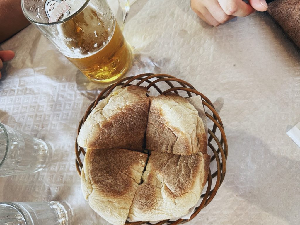 A basket of bread served with a glass of beer in Madeira