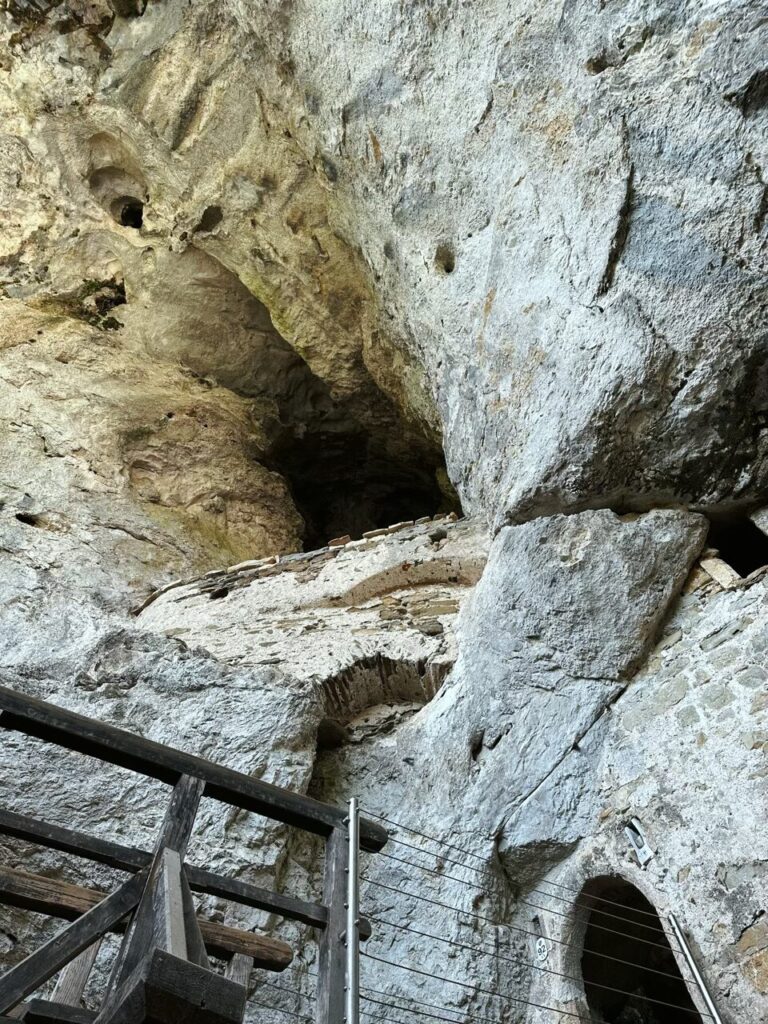 Stone walls of Predjama Castle built directly into a large cave opening
