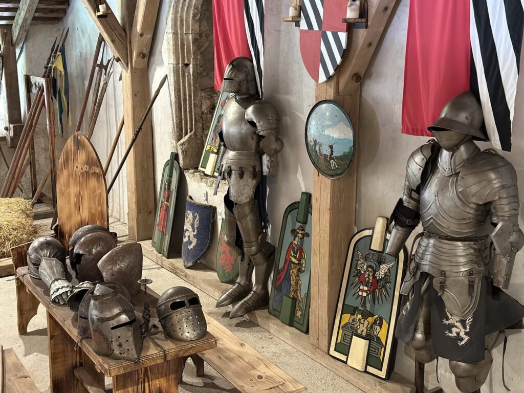 Suits of armor and medieval helmets displayed inside Predjama Castle