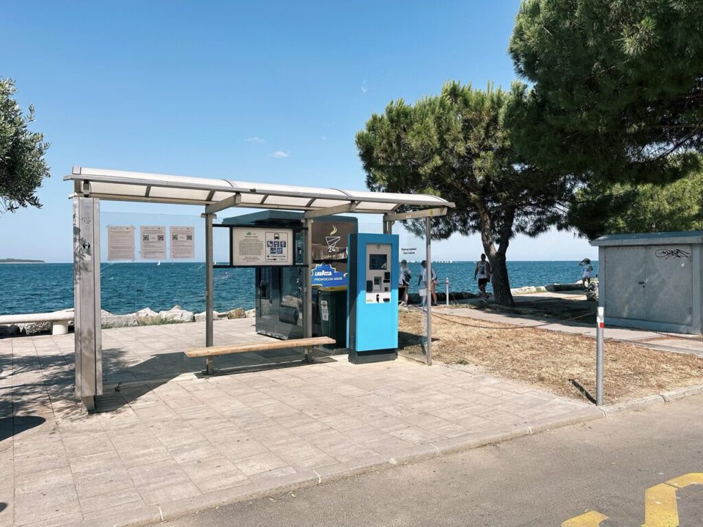 Bus stop shelter with a ticket machine overlooking the sea in Piran