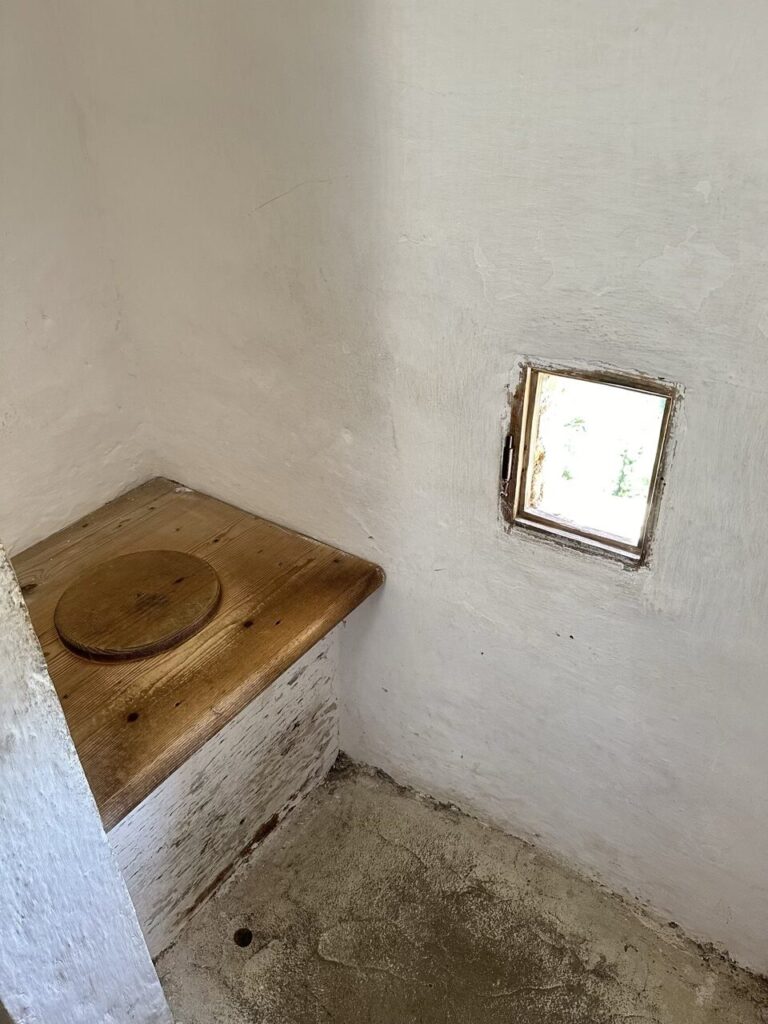 Wooden toilet seat inside a small room at Predjama Castle