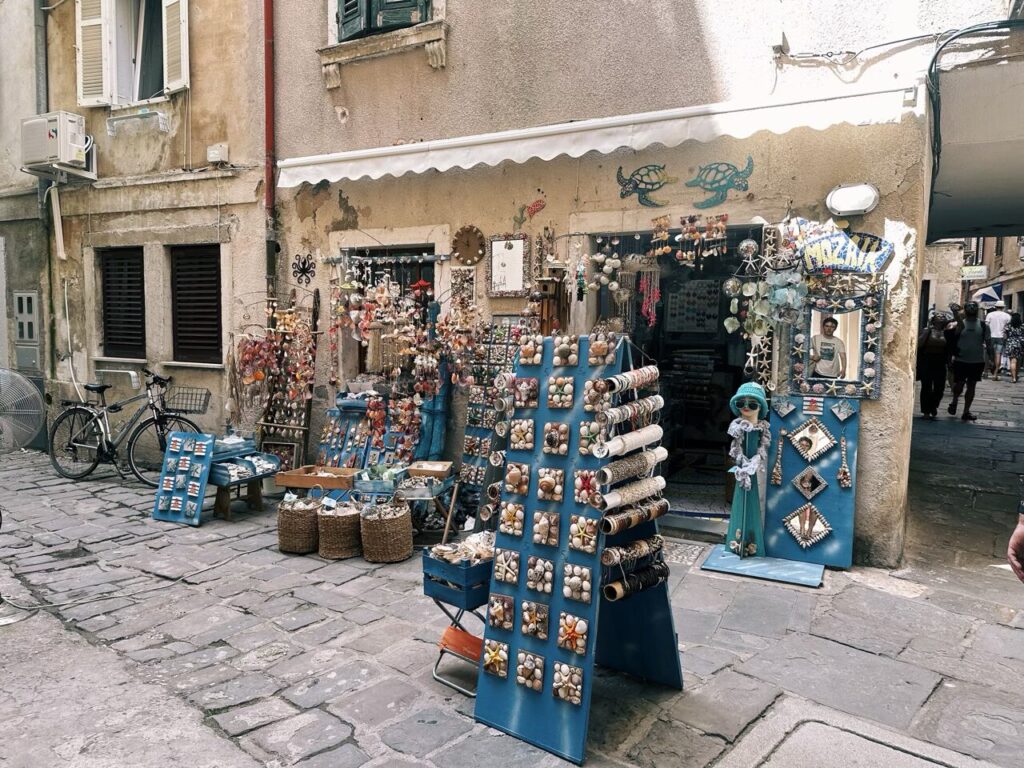 Souvenir shop in Piran displaying shell crafts and jewelry on a stone street