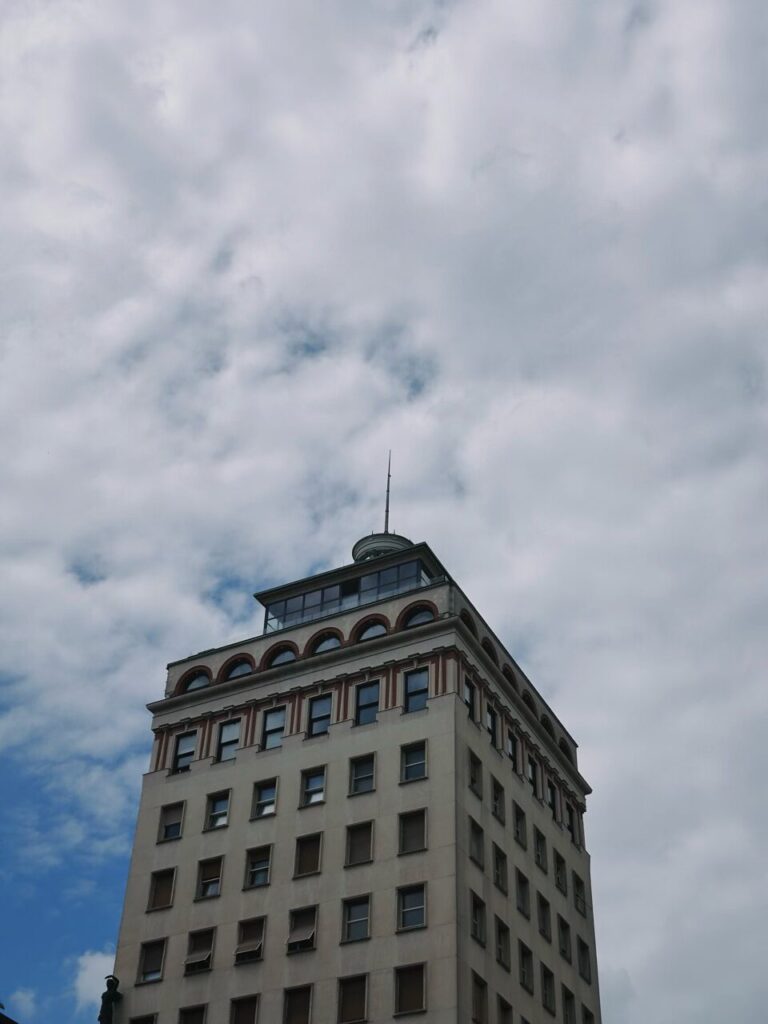 Tall building with arched windows against a cloudy sky in Slovenia