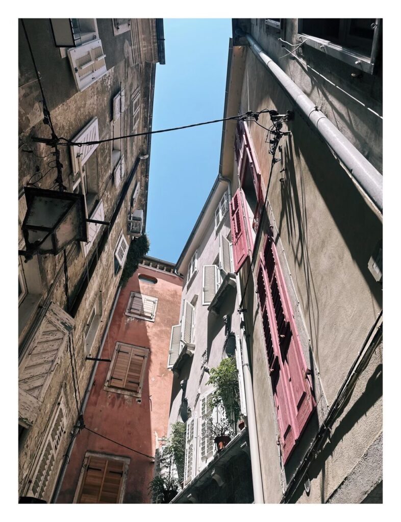 Narrow alleyway between tall colorful buildings in Piran, Slovenia