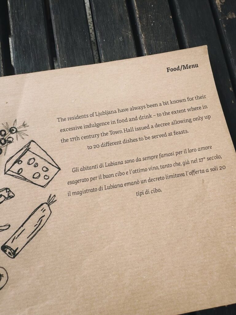 Text on a menu describes the history of excessive feasting in Ljubljana