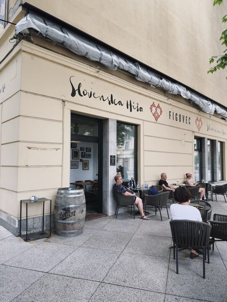 Patrons sit at outdoor tables in front of the Slovenska Hiša restaurant in Slovenia