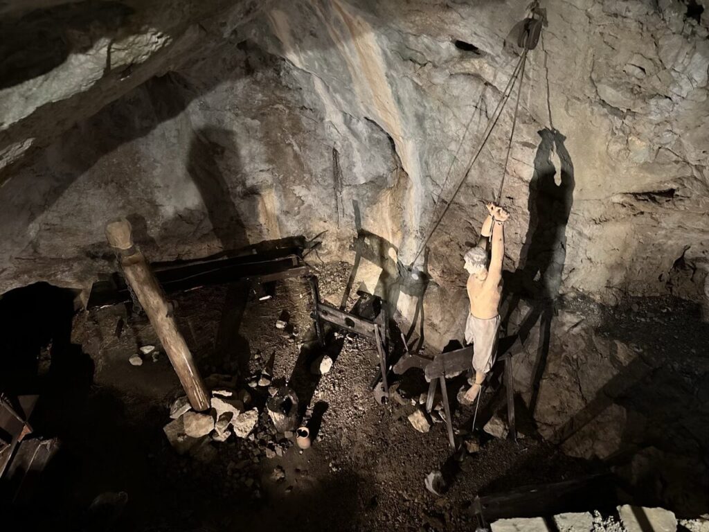 Mannequin of a prisoner suspended by ropes inside a Predjama Castle cave dungeon