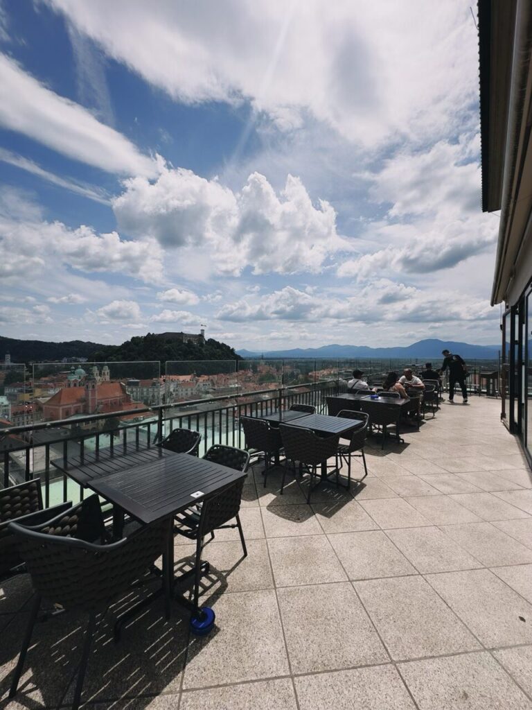 Outdoor terrace tables overlook the city of Ljubljana and its hilltop castle