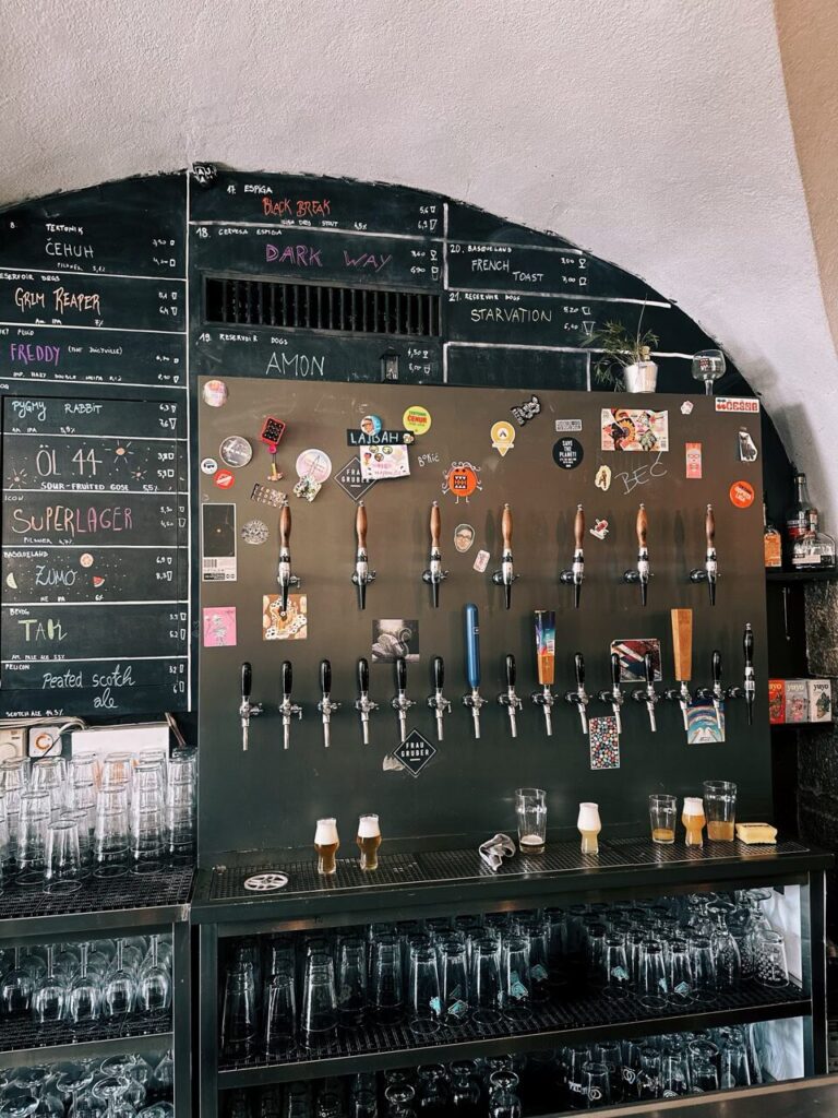 Rows of beer taps and a chalkboard menu inside a Slovenian bar
