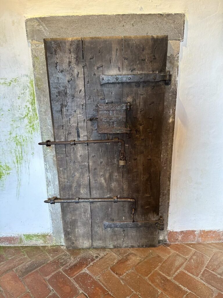 Heavy wooden door with iron reinforcements and padlocks inside Predjama Castle